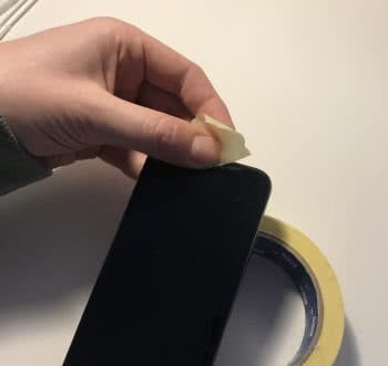 Clean iPhone speaker with adhesive tape.